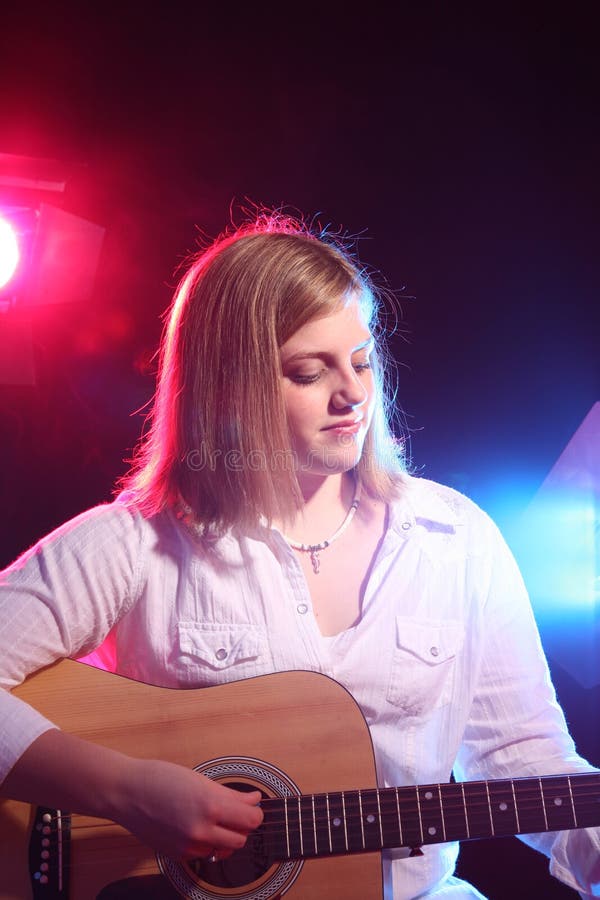 Bluesy teen with guitar and stage lighting