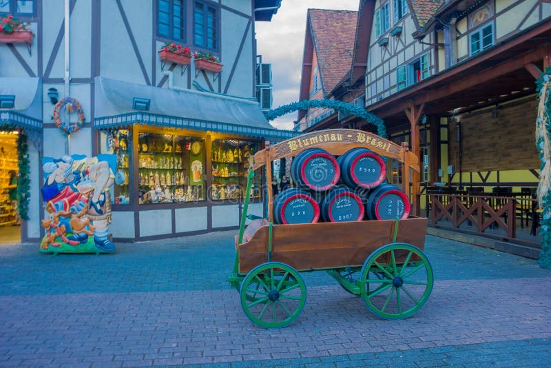 BLUMENAU, EL BRASIL - 10 DE MAYO DE 2016: el pequeño carro antiguo con algunos barriles de cerveza en él parqueó delante de algun fotografía de archivo libre de regalías BLUMENAU, EL BRASIL - 10 DE MAYO DE 2016: el pequeño carro antiguo con algunos barriles de cerveza en él parqueó delante de algun fotografía de archivo libre de regalías
