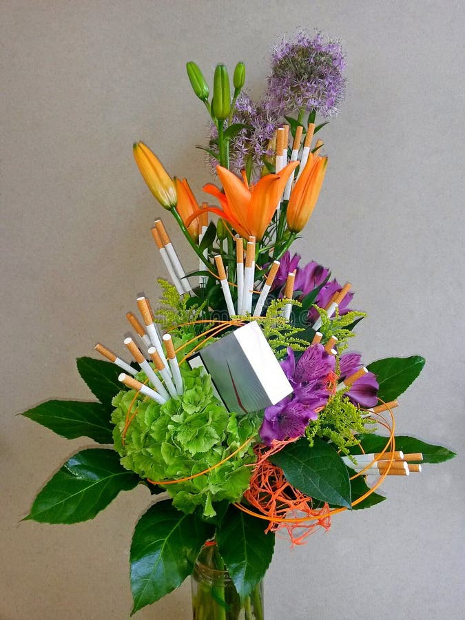 Blumenstraußblumen und -zigaretten im Glasbehälter, mit grauem Hintergrund lizenzfreies stockbild