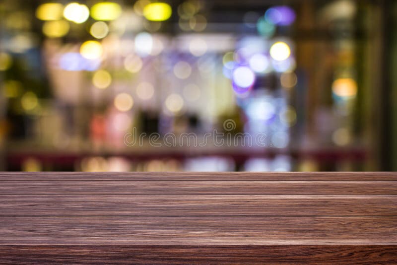 Blur cafe restaurant or coffee shop empty of dark wood table with blurred light gold bokeh abstract background for montage product royalty free stock images
