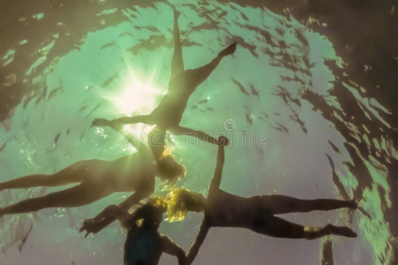 Blur photo - abstract image for the background. People holding hands floating on the surface of the water, shooting from below. royalty free stock photography