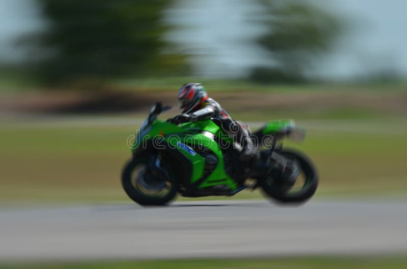 Blurred Athletes Practicing Racing Motorcycles on the Race Track Stock