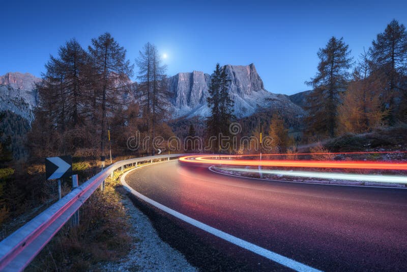 Blurred car headlights on winding road in mountains at night stock images