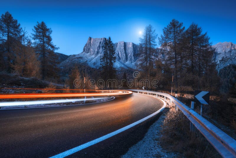 Blurred car headlights on winding road at night in autumn royalty free stock photos