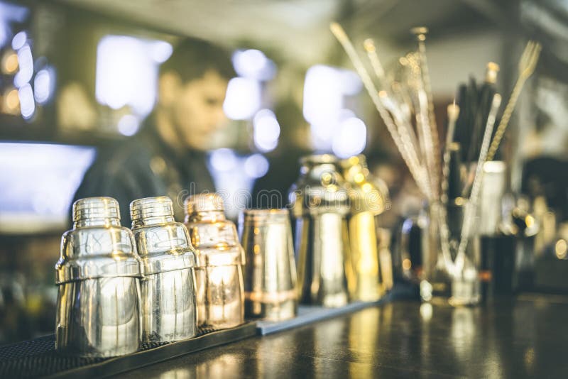 Blurred defocused view of barman preparing drinks at speakeasy cocktail bar on happy hour - Mixology concept with blurry bartender