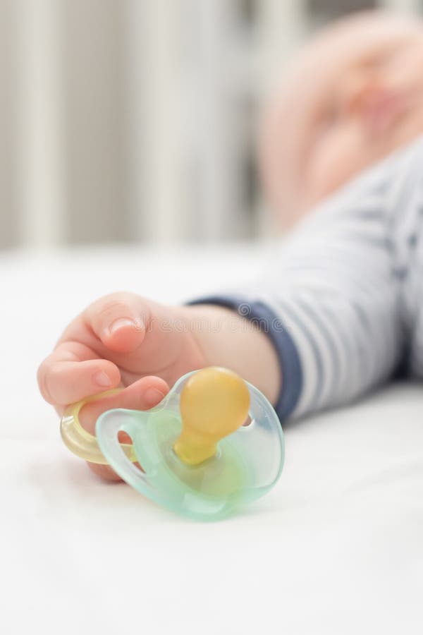Little Baby Boy Peacefully Sleeping in the Bed Holding Pacifier Dummy