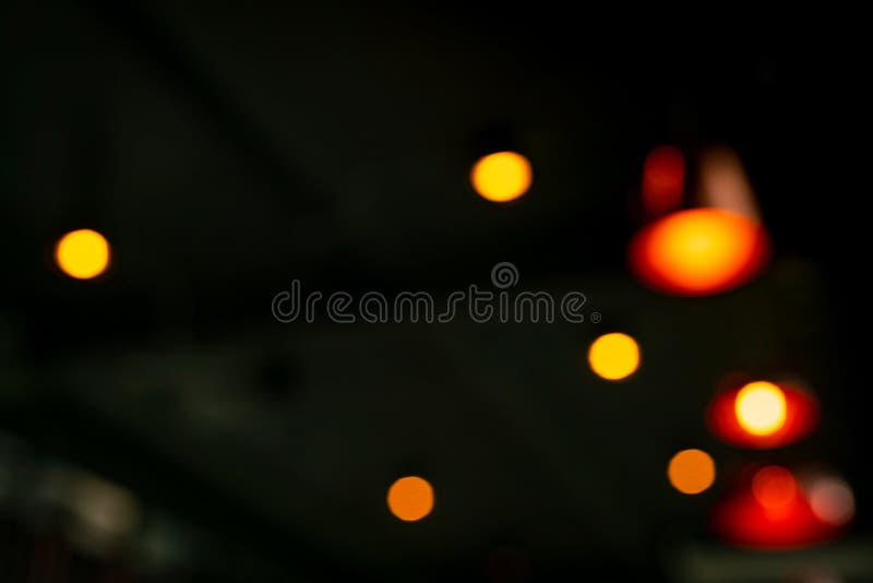 Blurred red, orange and yellow bokeh  abstract background. Blur bokeh on dark background. Street light effect with beautiful