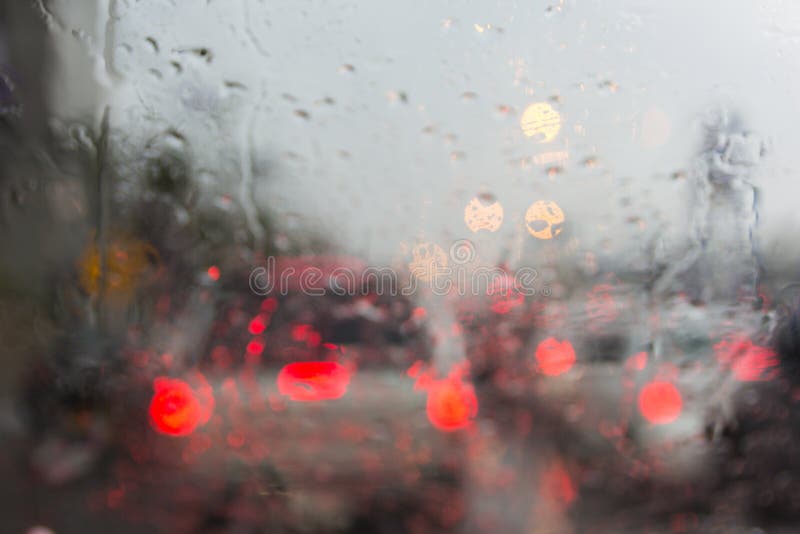 Blurry Car Silhouette Seen through Water Drops on the Car Windshield
