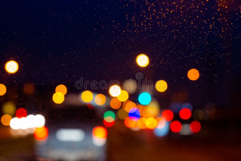 Blurry Lights on Car Glass on a Rainy Night, Blurred Background Stock