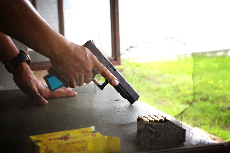 Blurry A man holding a gun in hand ready to shooting practice at targets paper royalty free stock image Blurry A man holding a gun in hand ready to shooting practice at targets paper royalty free stock image