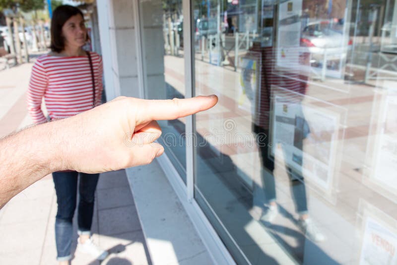 Blurry view of a young couple looking window display at real estate office window agent royalty free stock photo Blurry view of a young couple looking window display at real estate office window agent royalty free stock photo