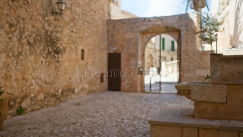 Blurter Blick auf einen historischen Campus-Kloster mit Steinmauern und Kopfsteinpflaster-Pfad unter sonnigen Himmeln lizenzfreie stockbilder