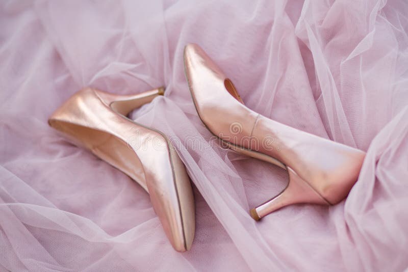Pink gold bridal shoes. Tender beige satin cloth texture background. Top view of lady`s pumps. Space for text. royalty free stock photography Pink gold bridal shoes. Tender beige satin cloth texture background. Top view of lady`s pumps. Space for text. royalty free stock photography