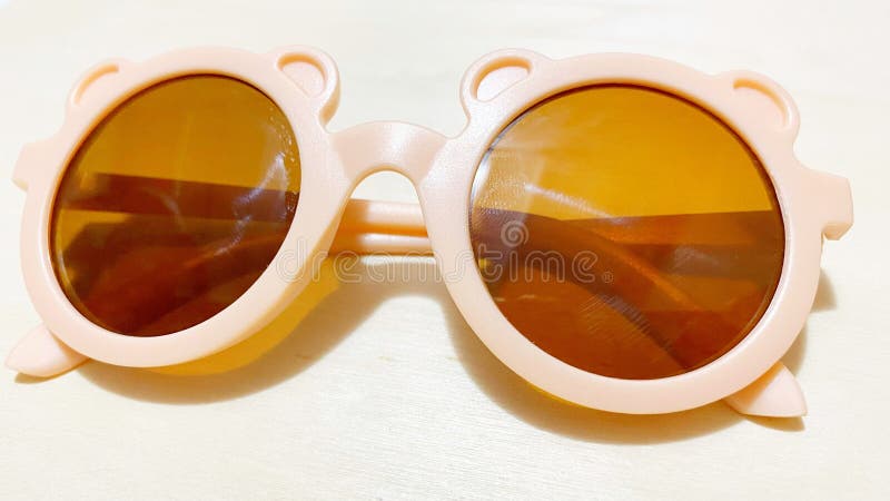 Brown children's glasses in the middle corner on a white background seen up close. Brown children's glasses in the middle corner on a white background seen up close