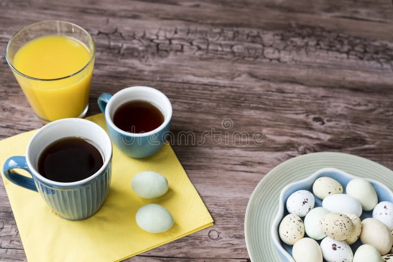 Blå bunke med pastellfärgade påskägg, på trätabellen arkivbilder Blå bunke med pastellfärgade påskägg, på trätabellen arkivbilder