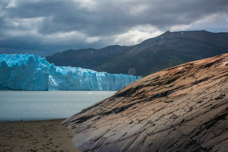Blå glaciär i bakgrunden av bergen nära fjärden Shevelev royaltyfri fotografi Blå glaciär i bakgrunden av bergen nära fjärden Shevelev royaltyfri fotografi