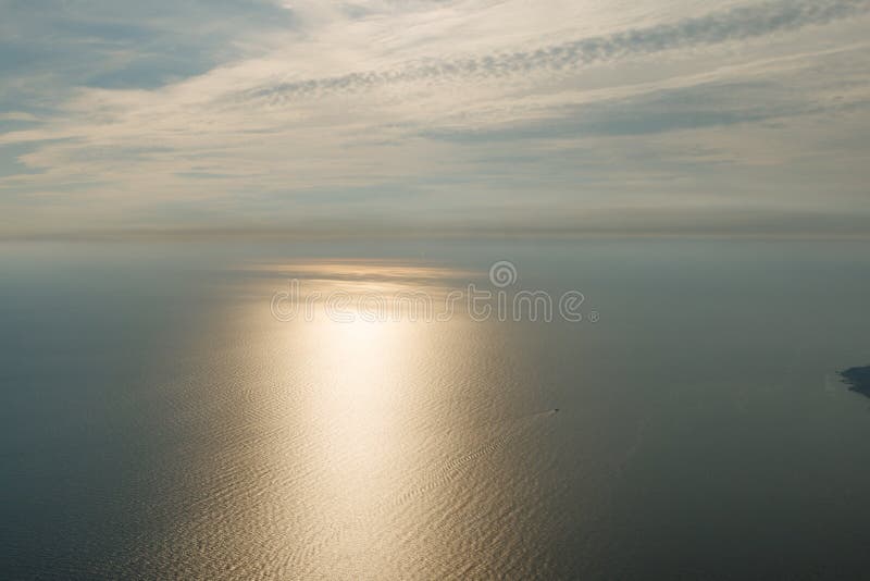 Blå himmel med moln och flygplanet skuggar över Blacket Sea Soldrevet på havsyttersidan och ett fartyg med fartyget skuggar på royaltyfri bild Blå himmel med moln och flygplanet skuggar över Blacket Sea Soldrevet på havsyttersidan och ett fartyg med fartyget skuggar på royaltyfri bild