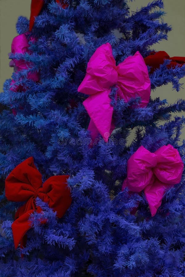 Blå konstgjord julgran med stora rosa bröst royaltyfri foto
