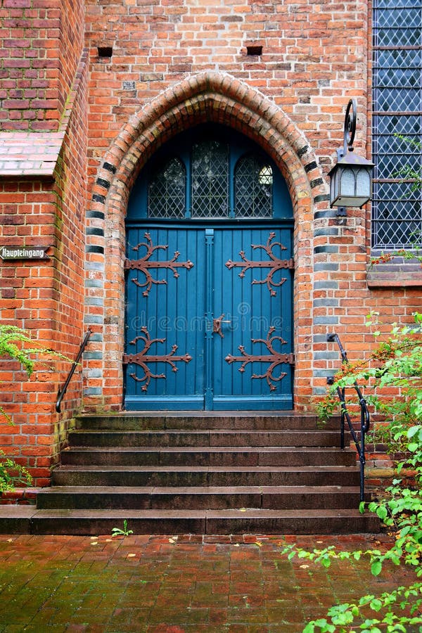 Blå trädörr, ingång till en gammal tegelstenkyrka arkivbild Blå trädörr, ingång till en gammal tegelstenkyrka arkivbild