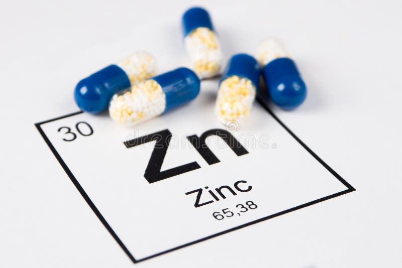 Blåa preventivpillerar med mineralisk Zn Zincum på en vit bakgrund med a arkivfoton Blåa preventivpillerar med mineralisk Zn Zincum på en vit bakgrund med a arkivfoton