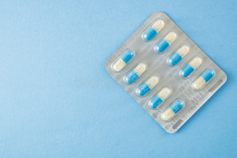 Blåsapacke av blåa och vita preventivpillerar på blå bakgrund med snuten fotografering för bildbyråer Blåsapacke av blåa och vita preventivpillerar på blå bakgrund med snuten fotografering för bildbyråer