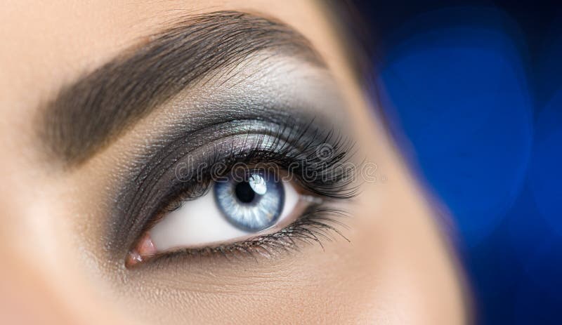 Blått öga för kvinna med perfekt makeup Härligt yrkesmässigt smink för smokeyögonferie Ögonbrynforma, ögon och ögonfrans