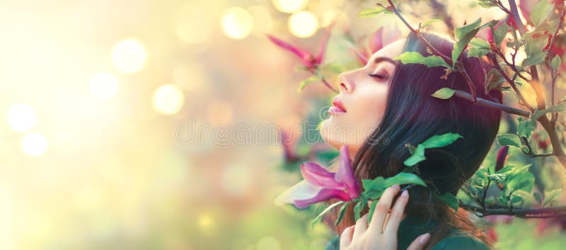 Blühende Magnolienbäume Berührenund riechende Frühlingsmagnolie der jungen Frau der Schönheit blüht lizenzfreie stockfotos