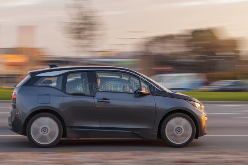 The BMW i3 electric car drives down the street at sunrise. Motion blur. Riga, Latvia - 06 Oct 2021.