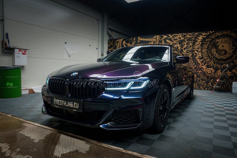 A sleek, dark BMW sits in a professional garage with a checkered floor and a graffiti mural, highlighting its modern design and the highquality tuning services of RESTYLING.EU. A sleek, dark BMW sits in a professional garage with a checkered floor and a graffiti mural, highlighting its modern design and the highquality tuning services of RESTYLING.EU.