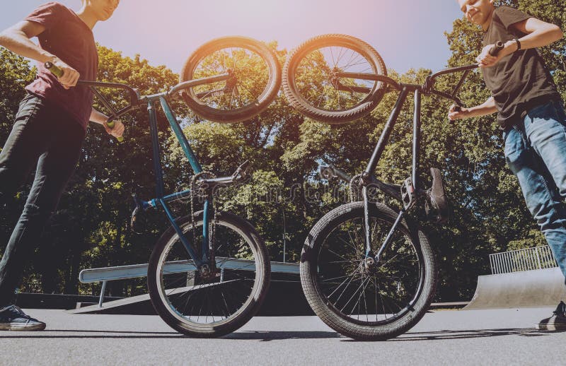 Bmx Riders Performing Tricks at Skatepark. Outdoors. Stock Photo