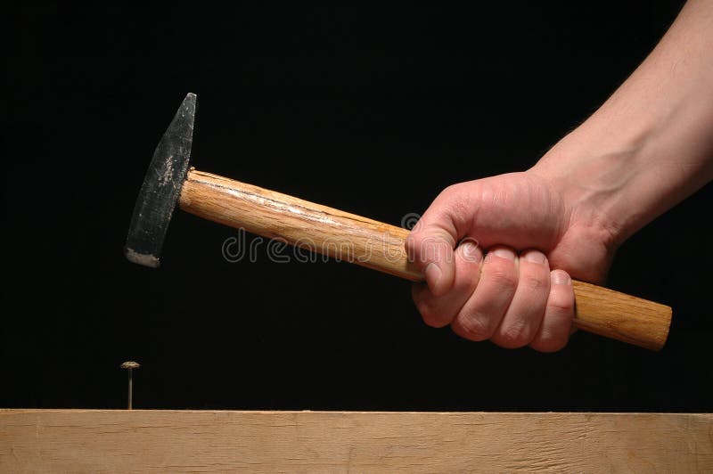 Manâ€™s hand holding hammer isolated on black background. Manâ€™s hand holding hammer isolated on black background