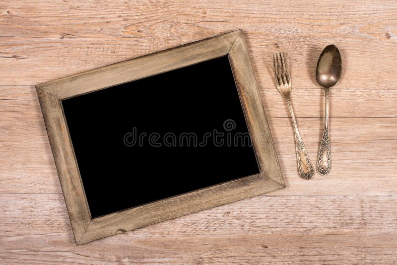 Board with frame of wood and fork and spoon stock images Board with frame of wood and fork and spoon stock images