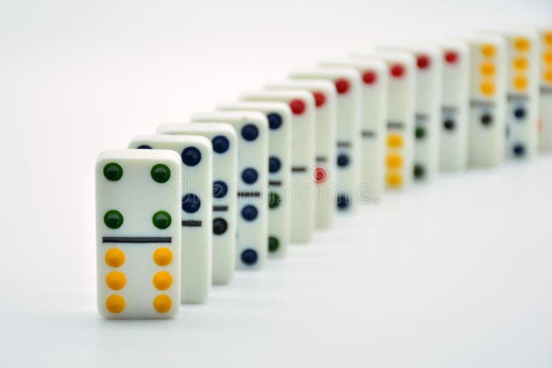Colored dominoes lined up, domino effect stock photography