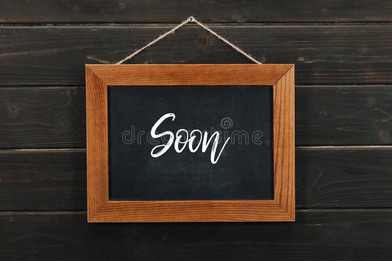 Board with lettering soon hanging stock photo