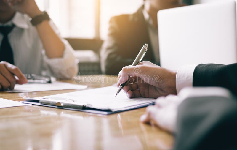 Boardroom with human resource business people writing paper negotiating a contract.