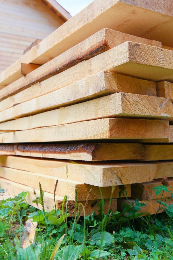 Boards in stack against wooden house
