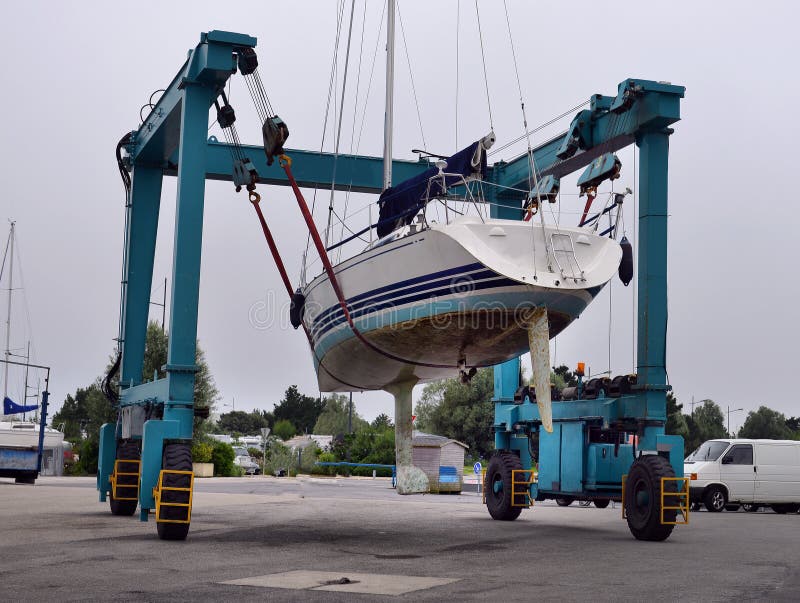 Boat crane lifitng a motorboat in the marina stock images Boat crane lifitng a motorboat in the marina stock images
