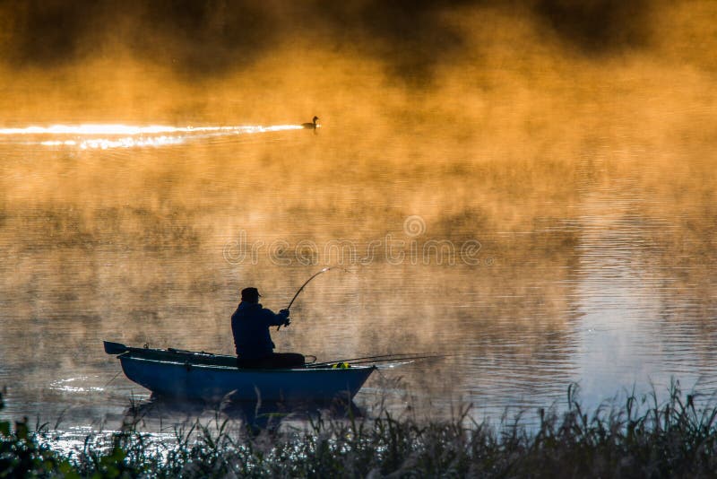 Nebbioso mattina due pescatori uomo un uccello il grande crestato subacquei nebbia arancia colore Perché da alba la luce.