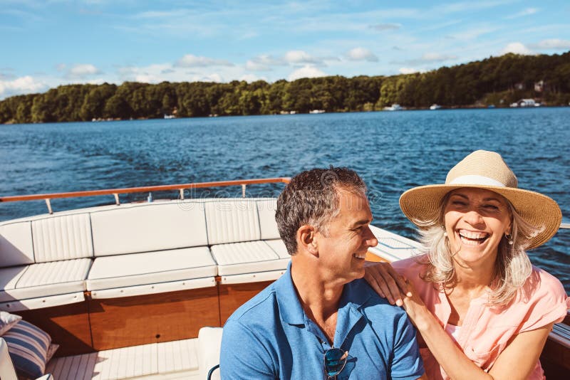 Boat, funny or travel with mature couple at sea together for holiday, getaway or vacation for anniversary. Laughing