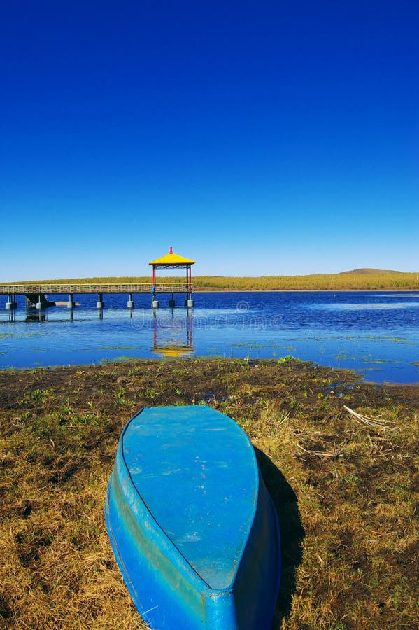 Boat and Lake. Boat near the Lake in Bashang grassland, Hebei, China. Bashang Grassland stretches from northern Hebei province into Inner Mongolia in China. It royalty free stock photography Boat and Lake. Boat near the Lake in Bashang grassland, Hebei, China. Bashang Grassland stretches from northern Hebei province into Inner Mongolia in China. It royalty free stock photography