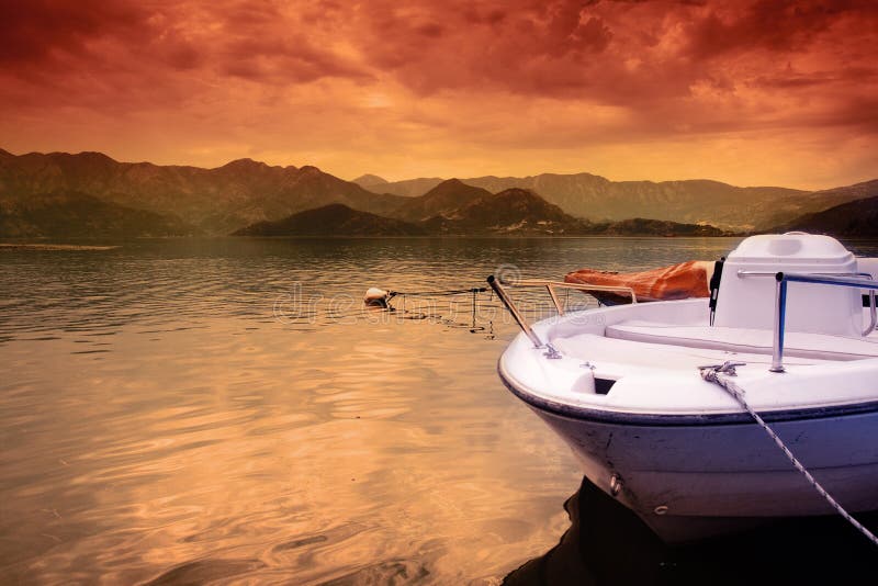 Boat on lake and colorful sunset sky