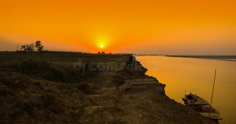 A boat on a river bank at sunset time royalty free stock photography A boat on a river bank at sunset time royalty free stock photography