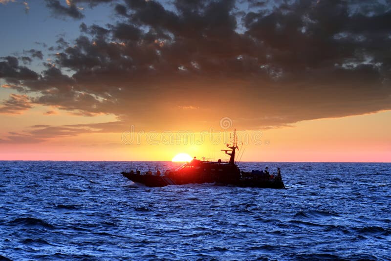 Coastguard sailing during the sunset