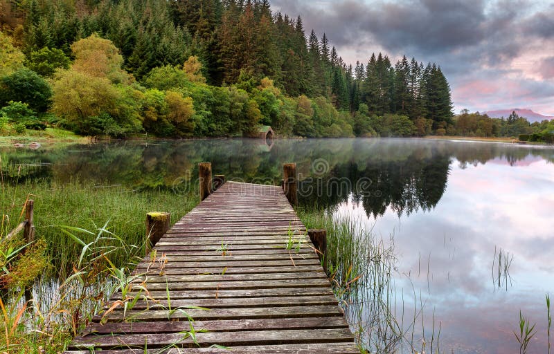 The old wooden jetty and boathouse on Loch Ard in the Scottish highlands. The old wooden jetty and boathouse on Loch Ard in the Scottish highlands