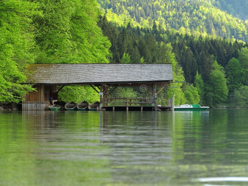 Idyllic scenery with a boat shed on the calm waters of a lake. Landscape idyll in Germany. Idyllic scenery with a boat shed on the calm waters of a lake. Landscape idyll in Germany.