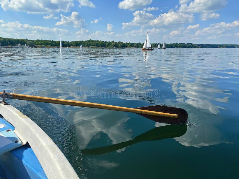 Boating on beautiful lake on blue sky and pleasant green landscape background and lovely reflection on water surface