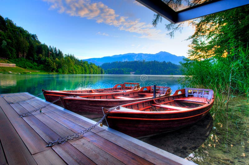 Boats on alpine lake in early morning stock photography