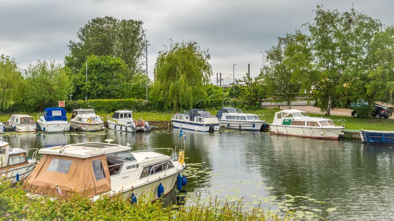 Boats of differing types and sizes line the banks of the River Great Ouse in Ely