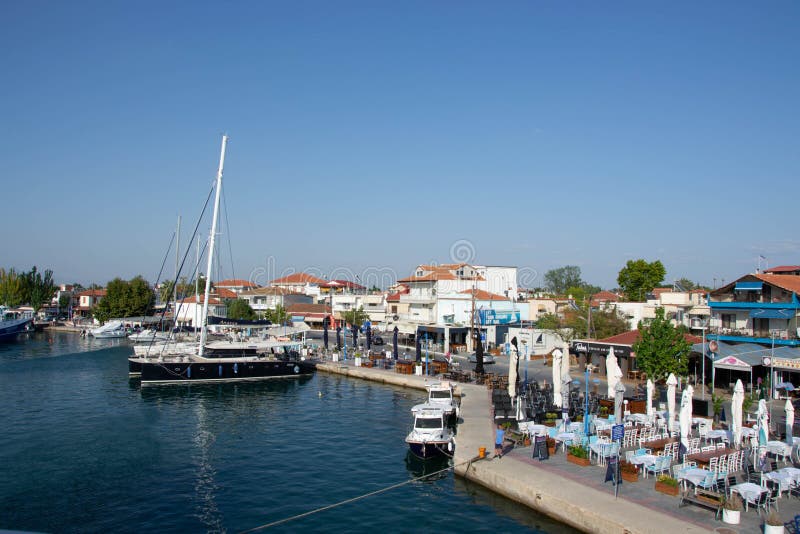 Boats at the port of village of Keramoti, Greece. Thasos island harbor, beautiful blue water and sky, tavernas, cafÃ©, restaurants