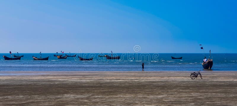 Boats on the Saint martin beach - Bangladesh`s largest island beach with boats sailing and a blue sky on the background